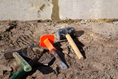 Defocus hammer, mallet, chisel and bayonet of the shovel lie on the ground. Set of tools for laying...