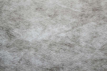 Defocus gray spunbond non-woven geotextile close-up macro. Close up. Small spots. Dirtied texture....