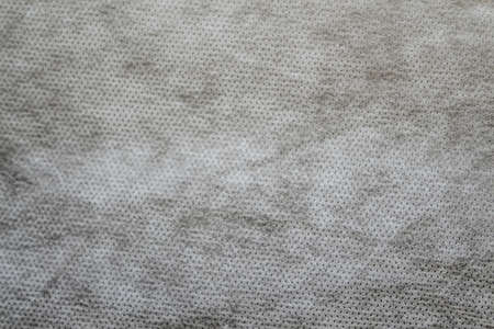 Defocus gray spunbond non-woven geotextile close-up macro. Small spots. Dirtied texture. Design, background, backdrop. Out of focus.の写真素材