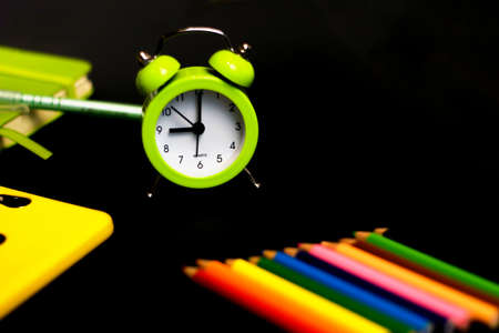 Back to school background with colored pencils and alarm clock. Concept with space for text or other elements on the subject of school and time management in elementary schoolの写真素材