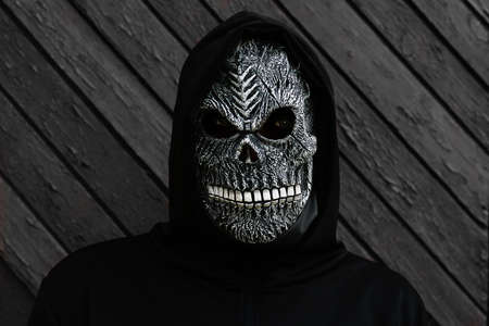 Halloween holiday concept. Death carnival costume. Scary death portrait. Death mask on black and...