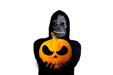 Isolated grim reaper holding halloween pumpkin head. Man in death mask with fire flame in eyes and grin on white background.Halloween holiday concept. Dark horror. Selective focus.の写真素材