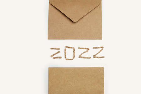 Blank eco card. Happy New year 2022. New Year Concept welcoming New Year 2022 written by craft rope or jute on white background. Two thousand twenty two. Eco envelope. Copy space. Border. Isolated.の写真素材