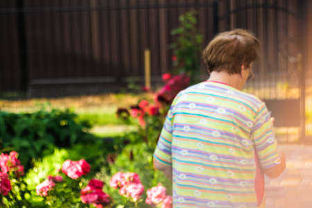 Old lady with wrinkled skin calling and speaking touchscreen smartphone. Nature background, close up, overhead, top view, copy space. selective focus.の写真素材