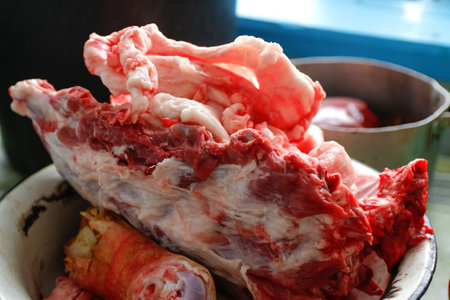 Chopped pork bones in aluminum plate. Pork meat concept close-up. Pig's head chopped off. no people. farmer concept. animal abuse. Pork meat. Farmer produce. side view. close-up. Entrails, liver.の写真素材