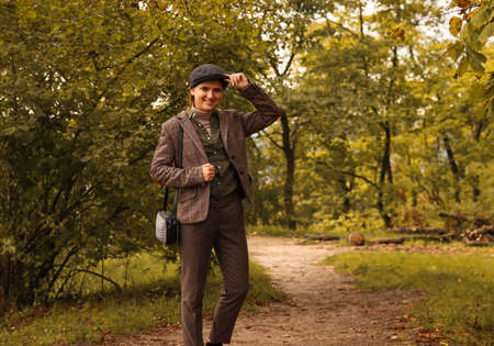 Woman wearing in british or english style clothes. Masculine woman. Young smiling woman wearing hat...