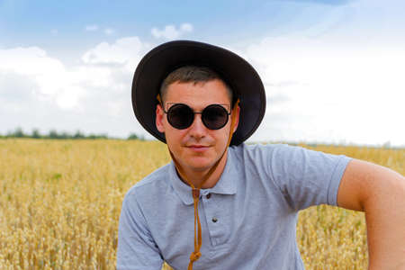businessman harvester. Portrait of farmer standing in gold wheat field with blue sky in background....