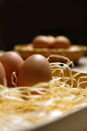 Rustic eggs on black background. Easter craft box with brown eggs on eco background. Chicken eggs on...