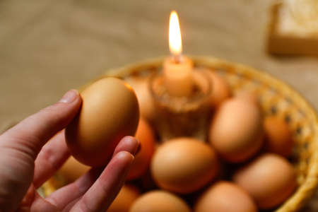 hand holding egg. Candle with light. rustic background. Paschal eggs, Pysankas. Collection of eggs...