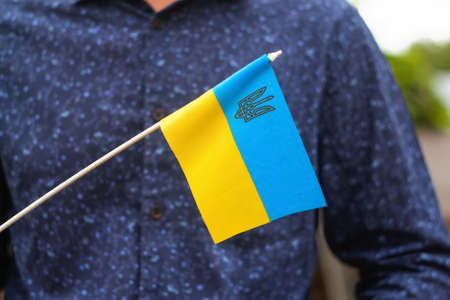 Photography of flag of Ukraine. Close up waving flag of Ukraine and emblem. Flag symbol of Ukraine. Person, people holding it outside. Victory of war. Patriot. Activistの写真素材