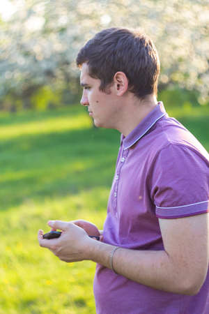Defocus smiling caucasian man outdoors portrait. Spring people. Young men in purple shirt on nature...