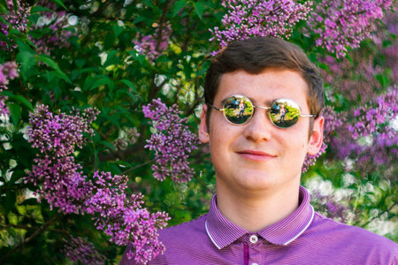 Defocus smiling caucasian man outdoors portrait. Spring people. Young men in purple shirt on nature...