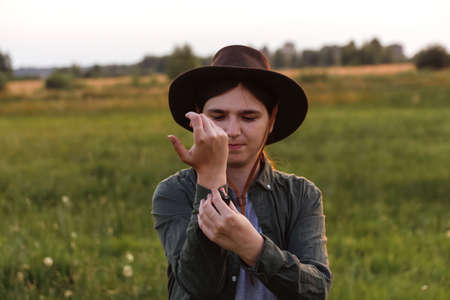 Defocus young woman in cowboy hat. Girl in a cowboy hat in a field. Sunset. Nature background....