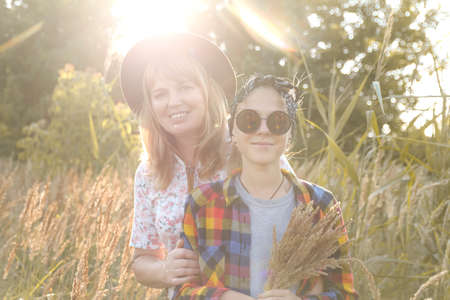 Defocus teen or preteen girl walking on nature background. Little kid girl holding bunch of pampas...