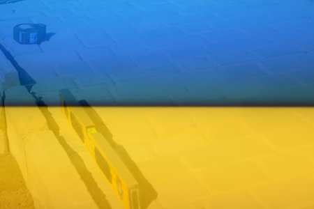 Defocus yellow spirit level and blue measuring tape on paving stone footpath. Sidewalk, driveway, pavement. Rebuild Ukraine. Construction industry. Out of focus.の写真素材