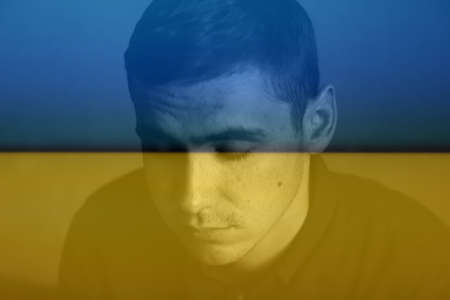 Defocus portrait of a young handsome man sad looking down in the park, the woods in autumn. Portrait on the nature of the park, the woods, on the street. Sad. Out of focus.の写真素材