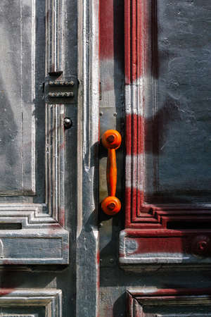 Defocus brown vintage telephone receiver on handle door. Closed wooden door building entrance on street with copy space on wall. Old doors. Out of focus.の写真素材