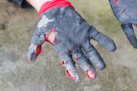Defocus worn dirty and leaky gloves. Open palms of hands in worn workers gloves, protection against...