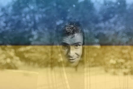 Defocus man wearing blanket. Flag Ukraine. Increase in the cost of gas bill. Soaring energy prices....