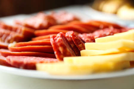 Defocus sausage and cheese. Antipasto catering platter with bacon, jerky, salami, cheese closeup...