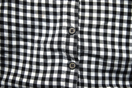 Defocus black and white shirt. Gingham tablecloth back pattern. Fragment of a wrinkled squared black...
