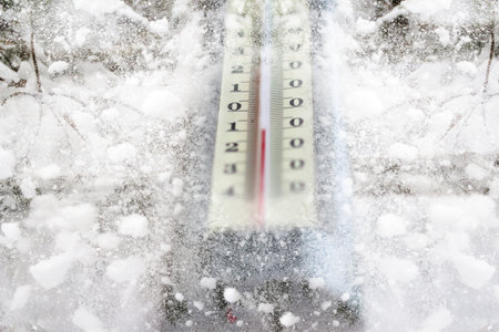 Defocus winter thermometer. Winter time. Thermometer on snow shows low temperatures in celsius....