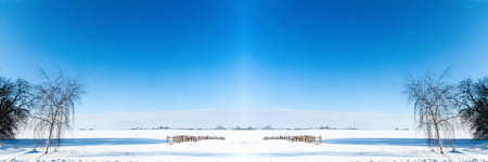 Defocus winter landscape in sunny weather. Winter beautiful landscape with trees covered with hoarfrost. Cracks on the surface of the blue ice. Banner frame border. Out of focus.の写真素材