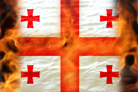 Georgia fire flame. Conflict war over border. Fire, flame. Georgia flag. Woman low rights. Male hands. Authoritarian law. Foreign agents. Fire and flame. Police. Out of focus.の写真素材