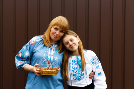 Easter family. Mother and daughter holding Easter eggs and hugging. Looking at camera. Ukrainian people. Out of focus.の写真素材