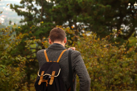 Back view of young brunette man walking. Man with rucksack in the forest. Back to school, Back of...