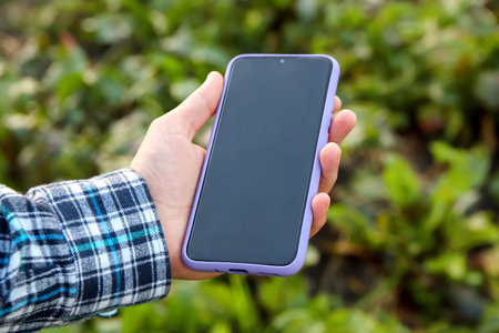 Phone mock up outside. Farm agriculture concept. farmer with mobile phone in hands in the corn field. Blank empty screenの写真素材