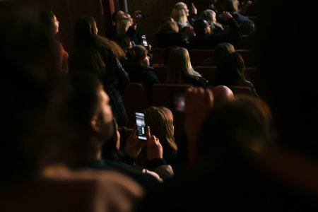 Spectators sit in the hall and watch a concert. People in the auditorium watching the performance....