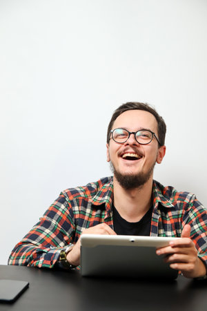 Young man using a tablet with a happy smile. Modern young man with tablet and happy expression....