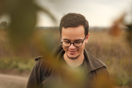 Young man with glasses. Young hispanic businessman smiling happy standing at the autumn nature...