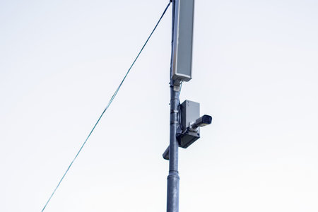 CCTV tool on grey sky background. CCTV camera monitoring a park for outdoor security. Surveillance...