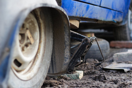 Old car jack. Hydraulic jack repair. Mechanic changing tire. Vintage car repair. Blurred.の写真素材