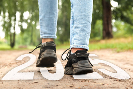 2025 New Year step forward in a forest, people walking towards future goals, concept of new...