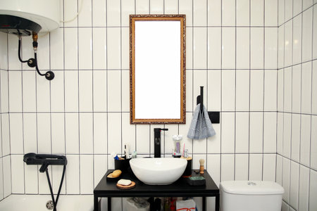A modern minimalist bathroom featuring a sleek white sink, black accents, and a large mirror reflecting the clean, stylish design. tiled wall with precise grout lines adds texture to the background.の写真素材