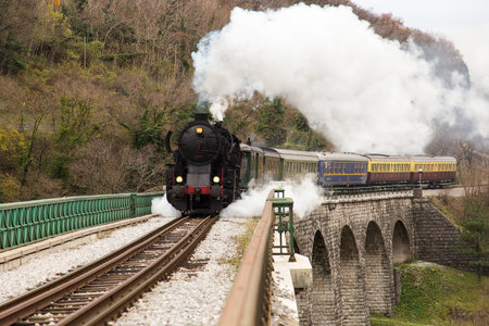Old Steam Train on old Stone Bridge over Soca Riverの写真素材