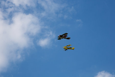 Two Old Biplane flying on blue Skyの写真素材