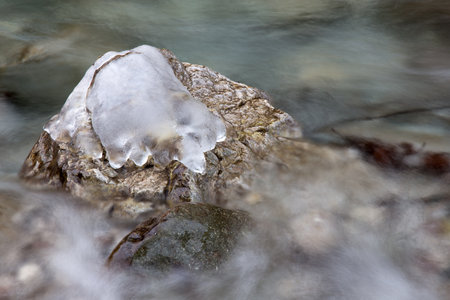 Ice on frozen rocks on River in the winter seasonの写真素材