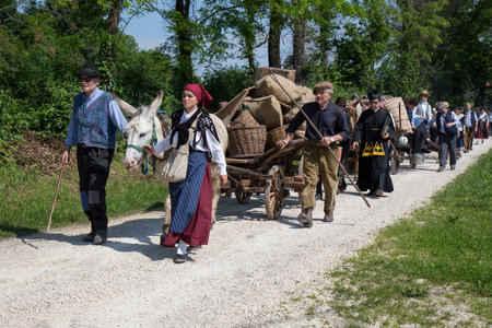 Farmers with old farm Wagons walking on the dirt roadのeditorial素材