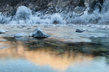 River landscape with frozen trees and Mountain Reflection, Soca river, Bovec, Sloveniaの写真素材