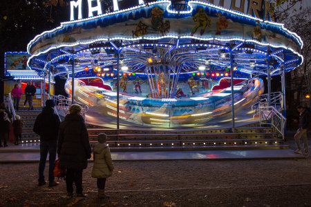 Carousel in the night - Family in Amusement park - Fair "Fiera di Sant'Andrea", Gorizia, Italyのeditorial素材