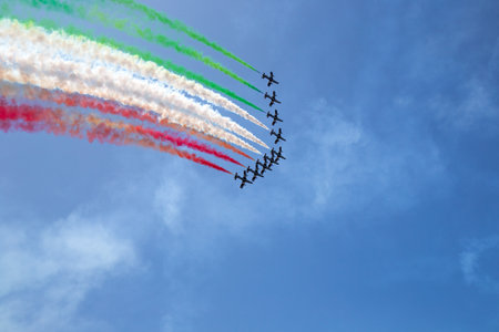 Frecce Tricolori - Airshow performance with trail of italian flag colors over Grado beach, Italyのeditorial素材