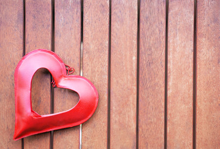 Red heart on the brown wooden wall left. Valentines day card background.の写真素材