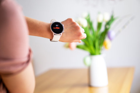 Hand of woman wearing smart watch on the Easter background. Technology, business and people concept.の写真素材