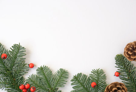 Christmas background with green branches, red berries and brown cones.