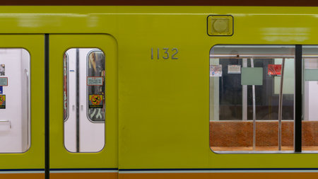 Tokyo, Japan - August 2018: An old, yellow train in a metro station in Japan with numbers on it