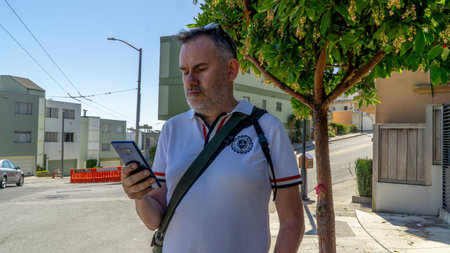 San Francisco, USA - August 2019: Man checking his phone on the street